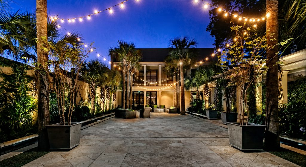 A stylish restaurant interior featuring a central tree, elegant furniture, and warm lighting.
