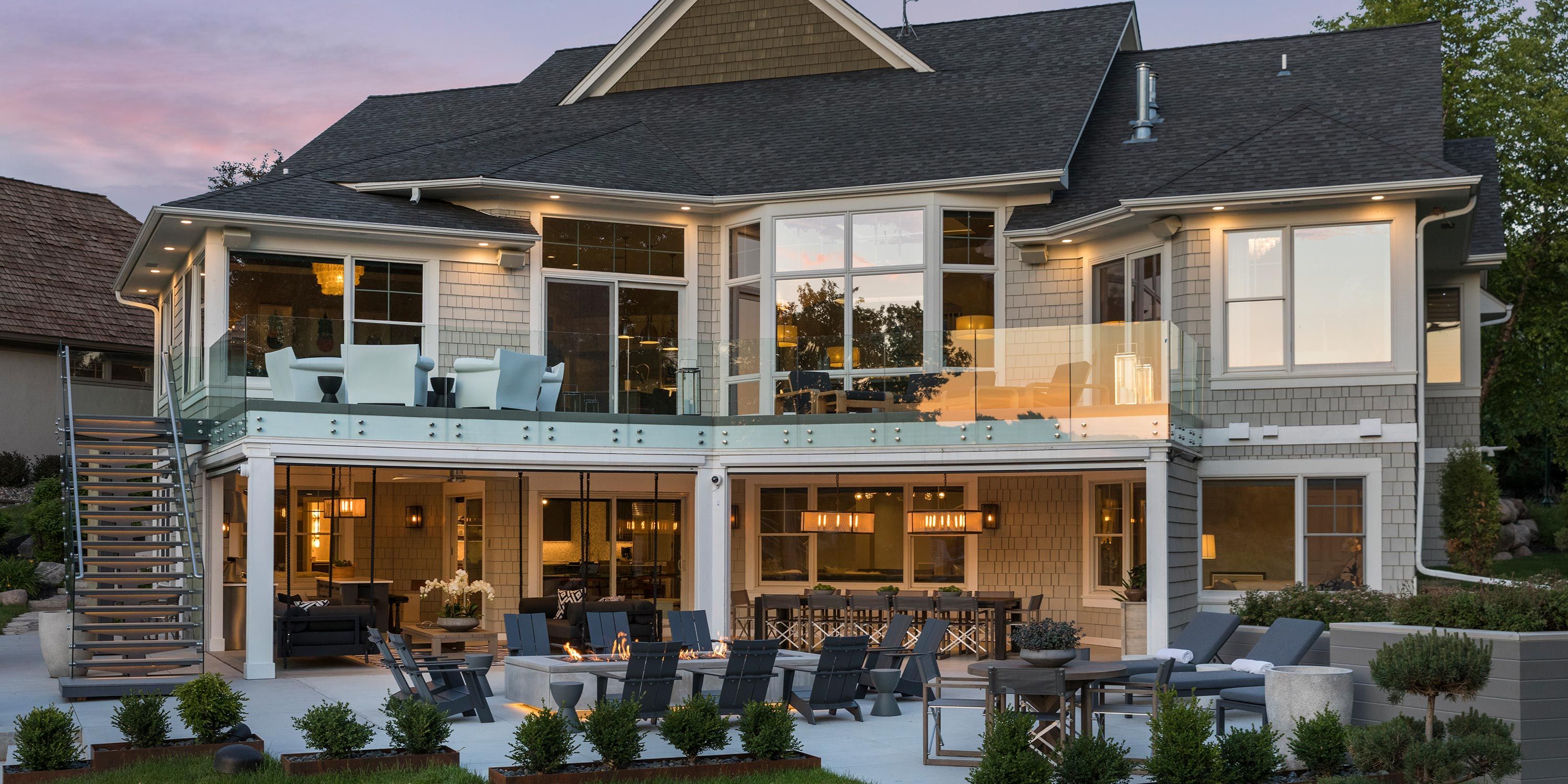 Luxury home with poolside lounge area and open indoor-outdoor living spaces framed by palm trees.