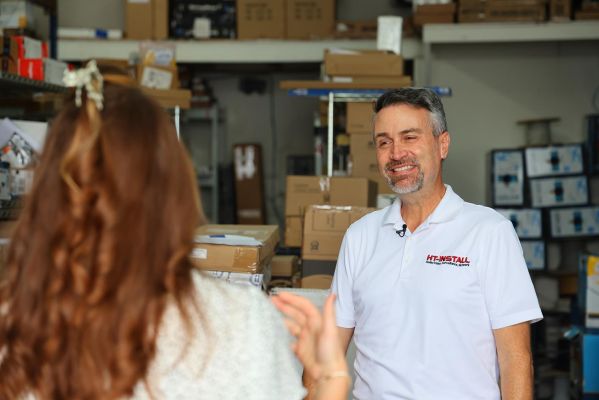 A professional conversation between two individuals in a warehouse setting.